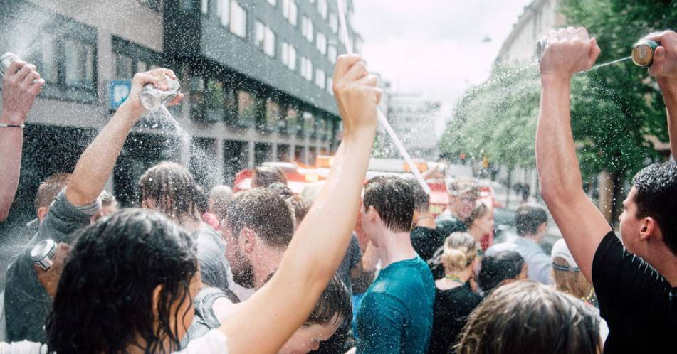 Studenter som firar och sprutar öl på varandra